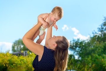 Obraz premium Mother keeps her son in her arms, and her son smiles