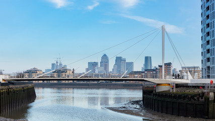 Modern Foot Bridge Across River With London's Financial District In Background