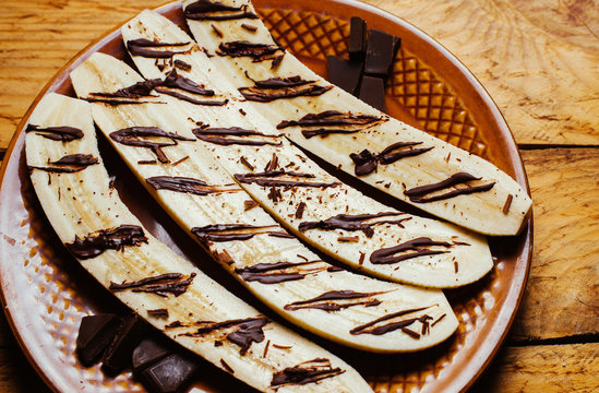Baked banana dessert with chocolate on wooden background table.  Recipe menu restaurant