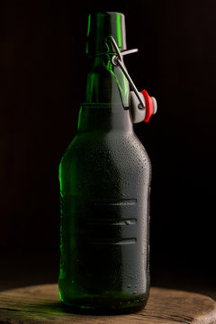 Beer bottle on table against black background
