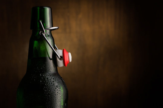 Close-up of green beer bottle against wooden background