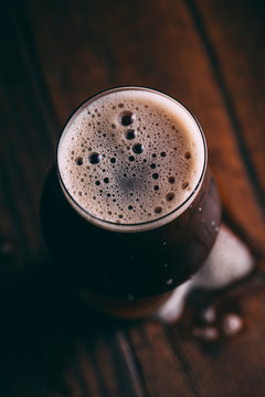 Stout beer in glass on dark background