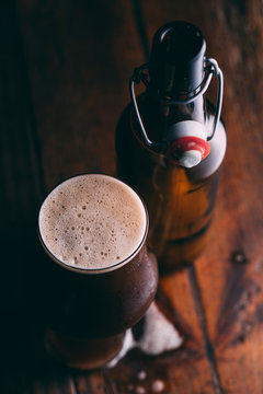 Stout beer in glass abd bottle on dark background