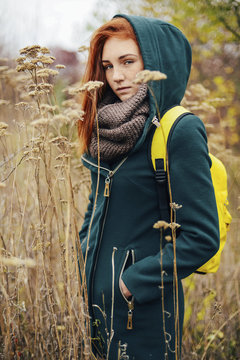 Portrait of teenage girl with backpack standing amidst plants