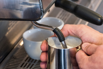 Steaming and frothing milk in tumbler for cappuccino or latte