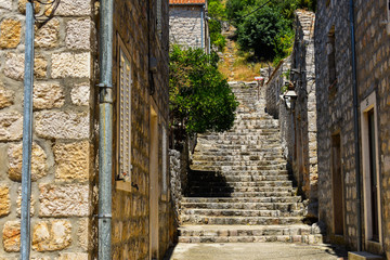 Fototapeta na wymiar narrow romantic street between houses in small village in Ston Croatia 