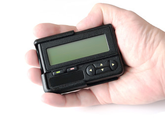 Old black beeper in hand isolated on white background
