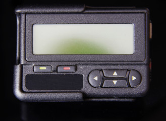 Fototapeta premium Black old pager or beeper isolated on black background 