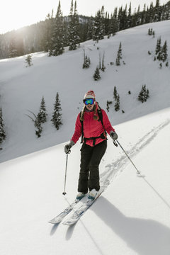 Woman skiing on snow covered mountain at forest