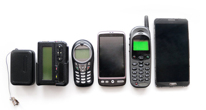 Old mobile phones and pagers isolated on white background