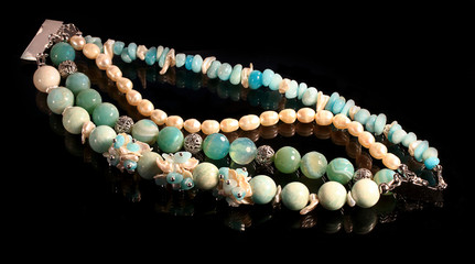 Handmade bracelet  from natural pearls  and agates isolated on black background
