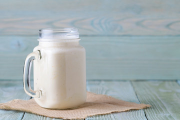 Smoothies of banana and tangerine in a glass cup