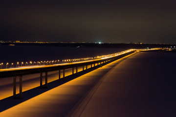Fototapeta premium Long bridge in night with cars light in modern city. Bridge on the Volga River