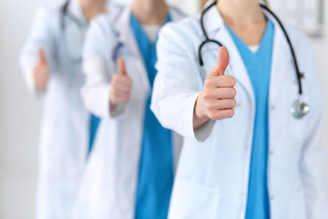 Groupe of medicine doctors show OK sign with thumb up close up. Success and high level service in...