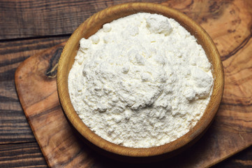 Fototapeta na wymiar Wheat flour in a wooden bowl, top view