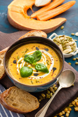 Delicious homemade pumpkin soup with basil leaves.