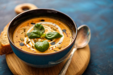 Delicious homemade pumpkin soup with basil leaves.
