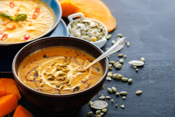 Delicious homemade pumpkin soup with basil leaves. Copyspace
