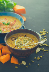Delicious homemade pumpkin soup with prawns, chili and basil leaves.