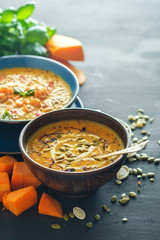 Delicious homemade pumpkin soup with prawns, chili and basil leaves.