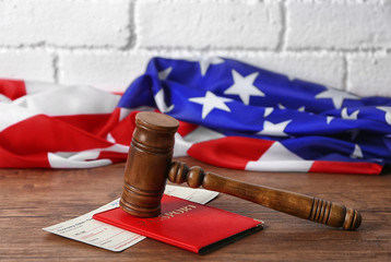 Gavel, passport, ticket and American flag on table. Legal immigration