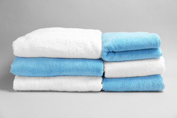 Soft bath towels on grey background