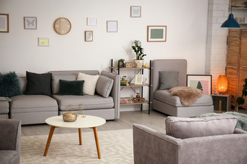 Modern living room interior with comfortable sofa and armchairs