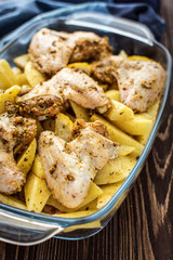 Raw chicken wings with potatoes marinated on a wooden background