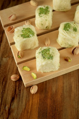Turkish dessert. Cotton candy with pistachio on wooden boards surrounded by nuts