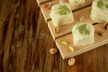 Turkish dessert. Cotton candy with pistachio on wooden boards surrounded by nuts