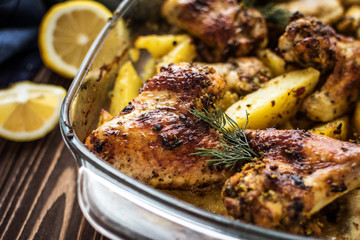 Baked chicken wings with potatoes on a wooden background