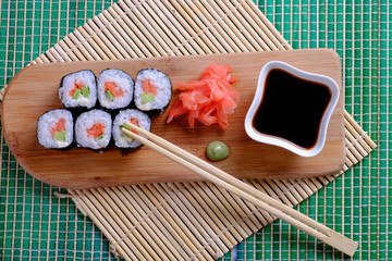 Ready rolls on a wooden stand, ginger, soy sauce, wasabi