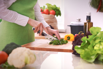 Close Up of human hands cooking vegetable salad in kitchen on the glass table with reflection. Healthy meal, and vegetarian food concept