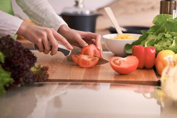 Close Up of human hands cooking vegetable salad in kitchen on the glass table with reflection. Healthy meal, and vegetarian food concept
