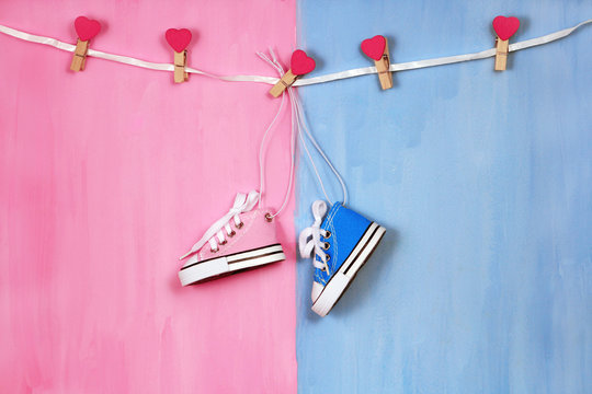 Baby sneakers on pink and blue background, baby shower party concept