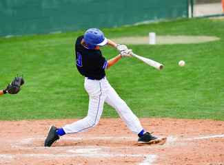 Baseball players swinging the bat at a fastball from the pitcher