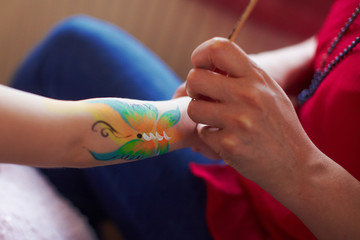 Artist is making butterfly picture on kids birhtday