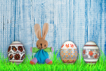 Happy Easter. Colorful easter eggs and rabbit on green grass.