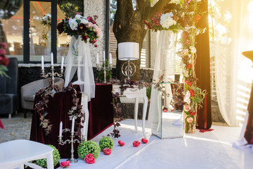 Sunset on wedding reception decorated with red / claret flowers