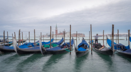 Fototapeta premium Venise, Italy - 03 10 2018: Le grand canal, ses gondoles et l'église San Giorgio Maggiore en fond avec pause longue