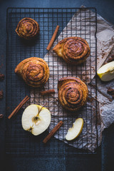 cinnamon rolls on the stone table, decoration with apples and cinnamon