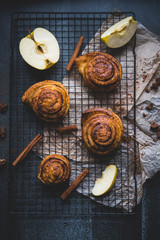 cinnamon rolls on the stone table, decoration with apples and cinnamon