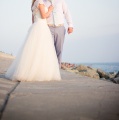 Obraz na płótnie Canvas The bride and groom on the beach