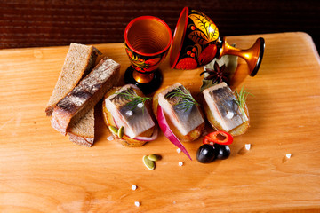 Pickled herring with chopped onions and a glass of vodka.