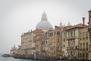 Fototapeta na wymiar Venise, Italy - 03 11 2018: Vue du dôme Santa Maria Della Salute avec en premier plan des façades colorées et des gondoles, vue depuis le grand canal