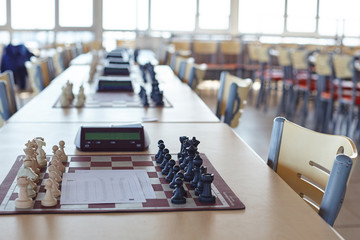 Chess tournament tables with chess timers and blank note papers © Ekaterina