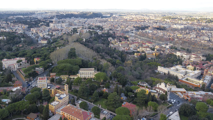 Panoramic aerial view of the northern area of Rome, Italy, on a sunny day. You can see a part of the river Tiber and in the background the dome of St. Peter's Basilica.