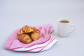 croissants on a red tea towel with a cup of coffee 