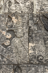 Mayan ball player sculpted on bas relief on the court wall. Detail on Chichen Itza stadium carved on stone. Players had feathered helmets and leather padding for protection. The winner was beheaded. 