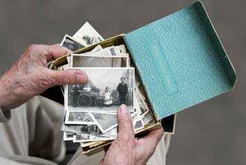 Senioren schaut sich alte Familienfotos an, Erinnerung an die Vergangenheit - 197692662